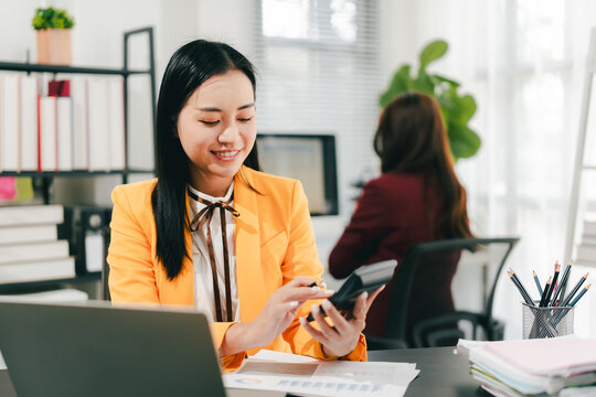 Young Asian woman doing financial accounting and taxes for a company Organizing account analysis reports Investment information Financial and tax system concepts