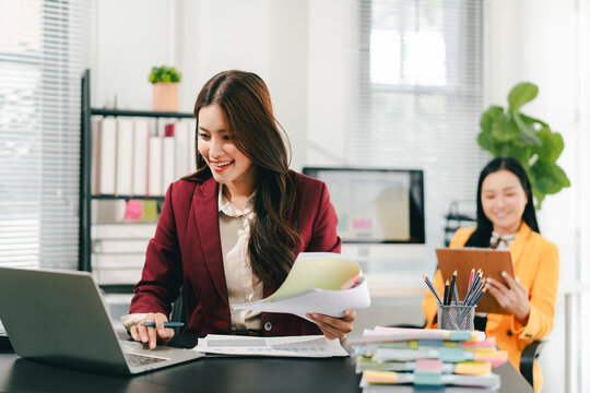 The female employees are working and searching for documents. The female accountant is preparing the company's annual taxes.