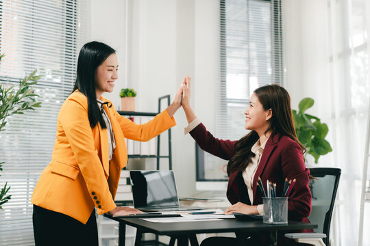 The businesswoman and men shook hands and signed the agreement. This demonstrates teamwork.