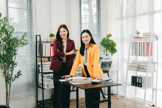 Two businesswomen were having an informal conversation. The two women greeted each other and began discussing a matter.