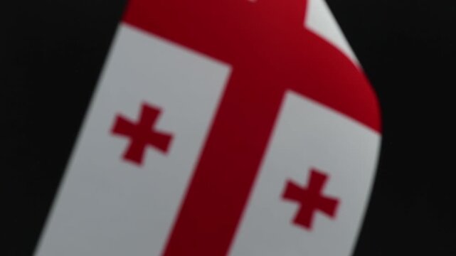 Georgian flag waving with soft focus on a black background. This visual is suitable for depicting national pride, cultural identity, or international events.