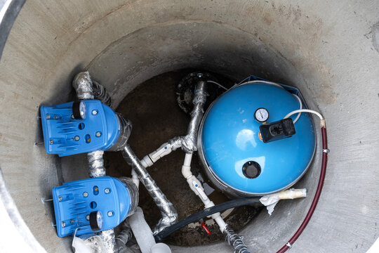 Installed equipment in artesian water well: pressure tank, filtration system, water pump, plumbing for house water supply, clean well solution.