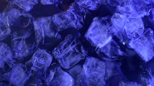 Top view of ice cubes floating on the water surface, illuminated by blue light. Concepts for beauty advertising, menu designs for bars and restaurants, cryotherapy.