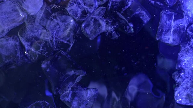 Top view of ice cubes floating on the water surface, illuminated by blue light. Concepts for beauty advertising, menu designs for bars and restaurants, cryotherapy.