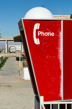 Vintage roadside telephone booth in desert setting, retro communication