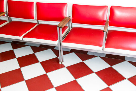 Vintage barber shop waiting area with red chairs and checkered floor