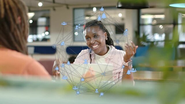 Woman explaining, gesturing at table, blue network overlay appearing over laptop, showing marketing