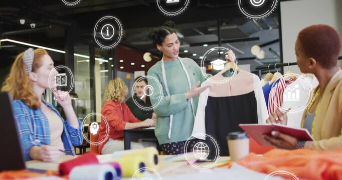 Holding designer in green sweater raising two-tone dress on hanger in studio, with measuring tape