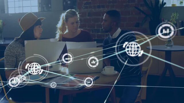 Team reading papers, viewing laptops, designing as single node popping network growing over laptops