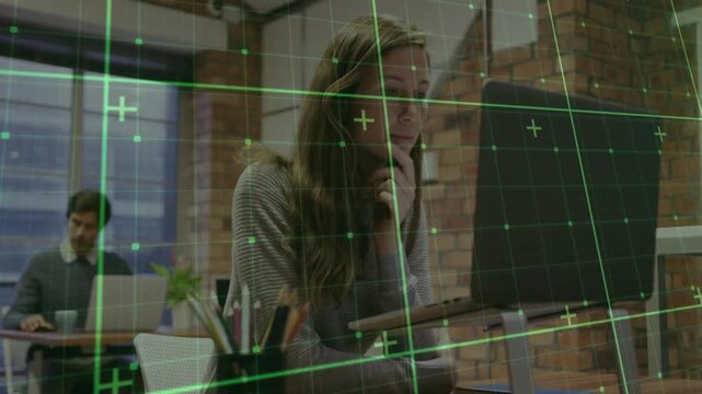 Female employee typing and tapping laptop in office, analyzing data, causing green grid sliding