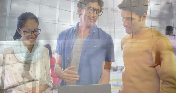 Lead pointing trackpad and demoing while team reviewing business task, grid overlaying laptop