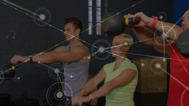 Fitness class holding KBs, hold sparking network over group, doing synced front raises for fitness