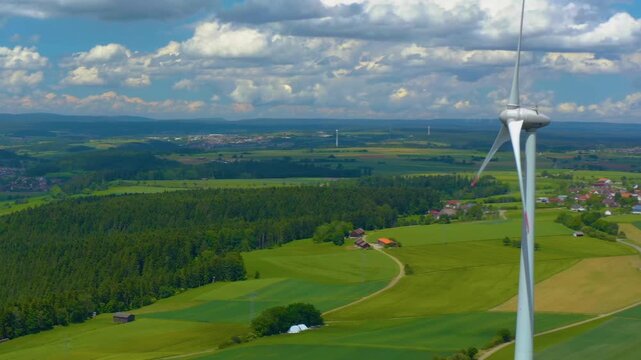 Aerial view of a wind turbine close to the Black Forest in Germany with a parallax  pan on a sunny day.