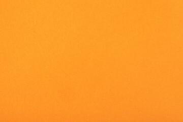 Fototapeta premium Bright orange textured paper background, ideal for creative designs, crafts, invitations, and digital presentations.