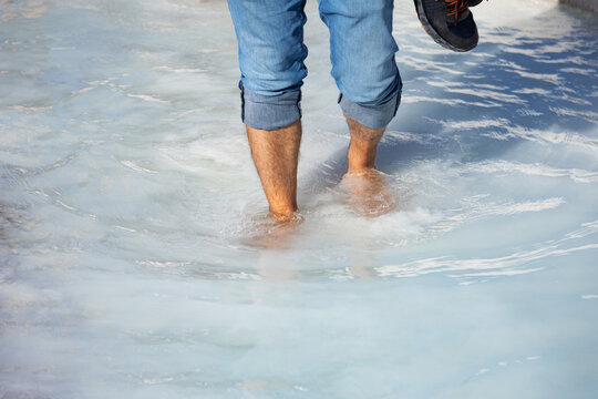 Person wades through mineral-rich waters in Pamukkale