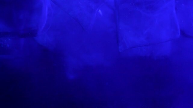 Ice cubes falling into water with oxygen bubbles, frost patterns, and soft light reflections. Concepts for beauty advertising, menu designs for bars and restaurants, cryotherapy.