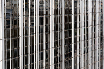 Fototapeta premium Abstract architectural detail of a contemporary skyscraper showing repetitive vertical steel and glass patterns