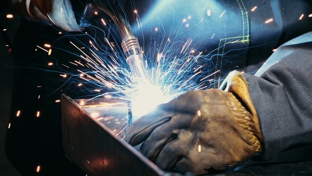 Intense blue arc with molten steel pool. Studio lighting highlights heat and energy of welding process