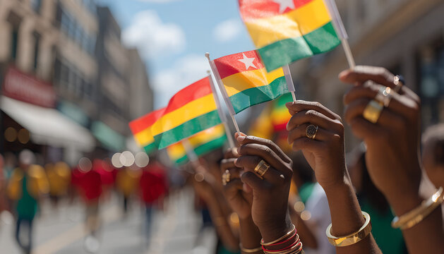 Group of people holding colorful flags during Juneteenth parade in city street with soft focus background perfect for diversity campaigns cultural celebration content and community event visuals