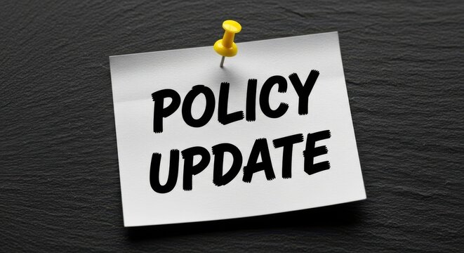 Policy update text on white sticky note, corporate compliance notice pinned to black wall, business regulation changes and legal document announcement