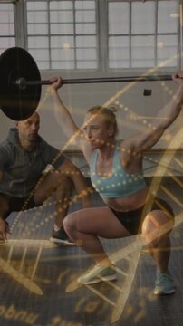 Athlete starting barbell overhead squat, coach spotting for training, gold DNA overlay tracing form