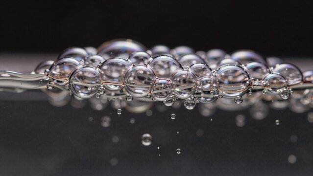 Close-up group soap bubbles reflective surface spherical shape transparent reflecting light creating shimmerin
