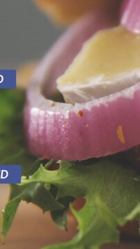 Vertical video: Lettuce onion rings cheese sitting as alert firing and badges floating over food PR