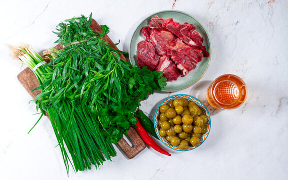 ingredients for cooking chakapuli, canned tkemali, meat, herbs Georgian cuisine, top view,
