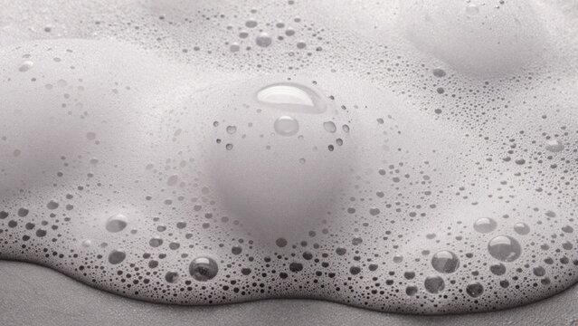 Black white close-up foamy surface likely bathtub shower gel smooth creamy texture predominantly numerous smal