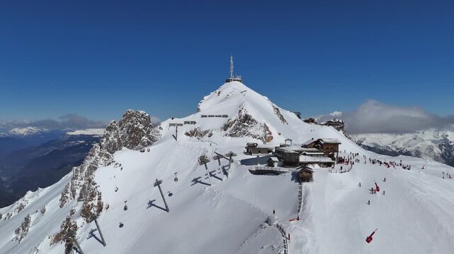 Aerial view of Courchevel and Meribel station in French alps with skiers on the slopes and snowcapped mountains by winter