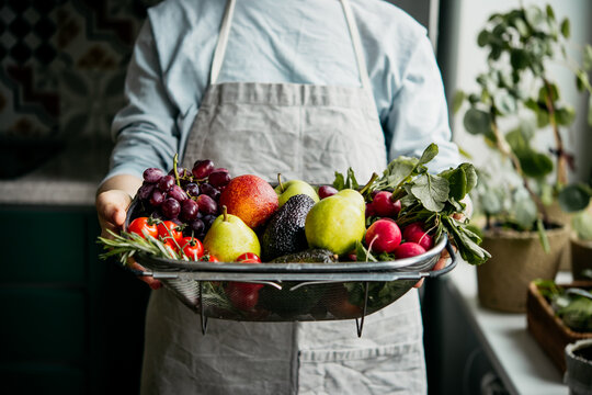 Hands holding big tray with different fresh fruits and vegetables. Harvest and healthy organic food concept.
