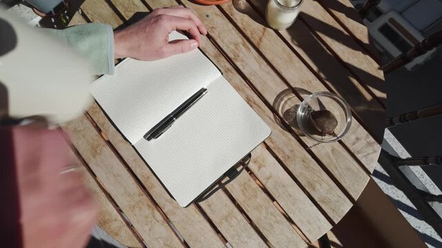 Enjoying a Relaxing Morning on the Balcony with Tea and a Notebook