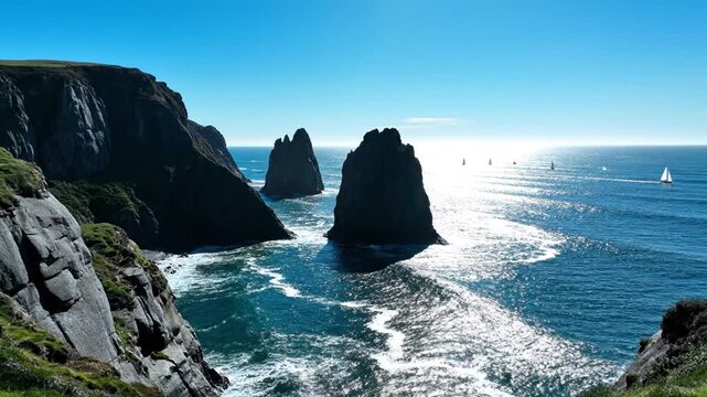 Dramatic coastal cliffs and sea stacks with sailboats on ocean