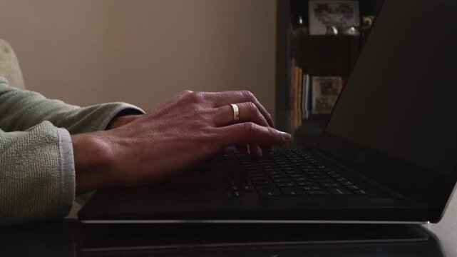 Person's Hands Typing on a Laptop Keyboard, Working from Home or Office