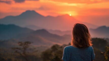 Obraz premium girl watching sunset mountains with blured nature background