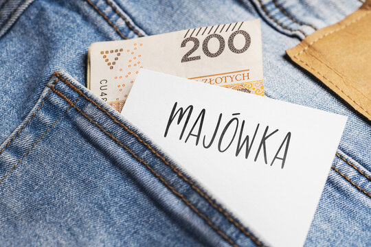 A banknote with a face value of 200 zlotys and a white card with the inscription "MAJ&Oacute;WKA" protruding from the back pocket of blue jeans