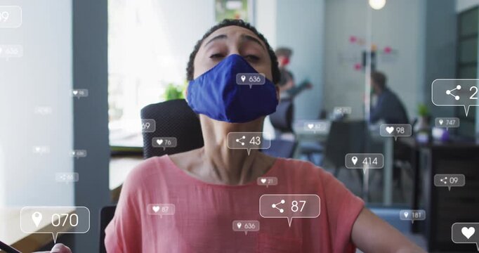 Animation of social media icons with numbers over businesswoman wearing face mask