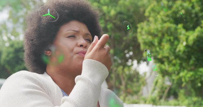 Woman issuing voice command garden showing floating power button CO2 turbine icons for energy tech