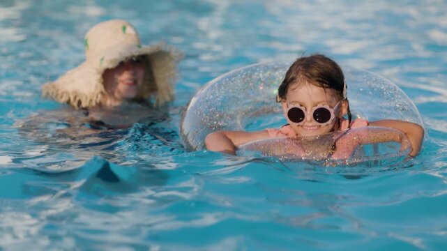 mom and daughter in pool have fun during summer vacation. Child having fun in swimming pool. 