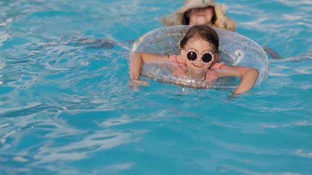 mom and daughter in pool have fun during summer vacation. Child having fun in swimming pool. 