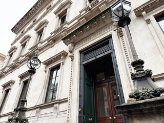 Fototapeta premium Historic ornate building entrance with stone facade and lamp posts in London, UK