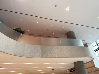 Fototapeta premium Modern curved lobby interior with mezzanine balcony and minimalist design in London, UK