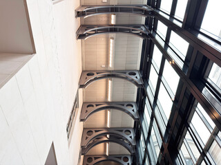 Fototapeta premium Modern interior atrium with glass and steel arches in London, UK showcasing light and symmetry