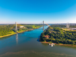 Aerial view of the International Integration Bridge connecting Foz do Iguacu in Brazil and Presidente Franco in Paraguay over the Parana River with lush landscape