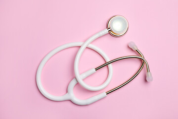 Fototapeta premium Stethoscope on pink background, top view. Medical equipment