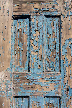 Old weathered blue wooden door with peeling paint texture