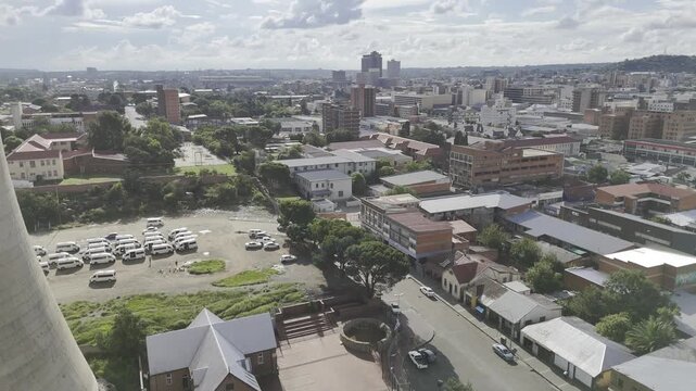 Drone descends on street next to power station towers beside Waaihoek Wesleyan Church ANC birthplace Museum on sunny afternoon in Bloemfontein, South Africa