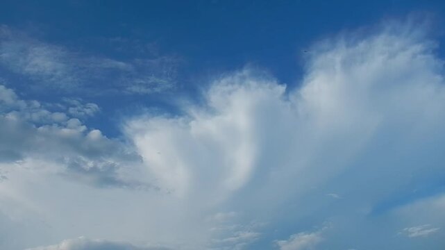 Blue sky with white Cumulonimbus Capillatus clouds - natural sky background slowly moving. Topics: Cumulonimbus cloud, Cirrus clouds, cloud types, weather, cloudscape, meteorology, nature, air space
