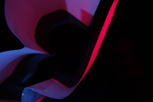 Trozos de papeles en deshuso con dobleces, generan espacios con ondas y curvas aleatorias,  con luz suave azul y magenta, forman un original dise&ntilde;o abstracto con fondo negro.