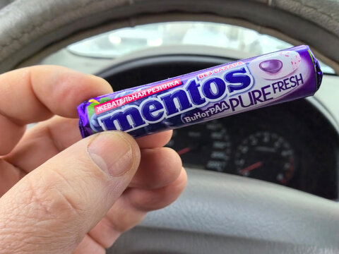 Mentos candy in hand captures refreshing moments inside a car